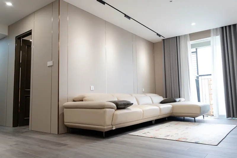 Phòng khách căn hộ — tường ốp tông kem, sofa trắng