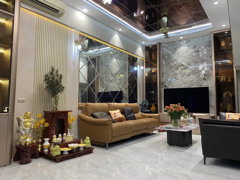 Phòng khách nhà phố — tường vân đá, trần ốp tráng gương