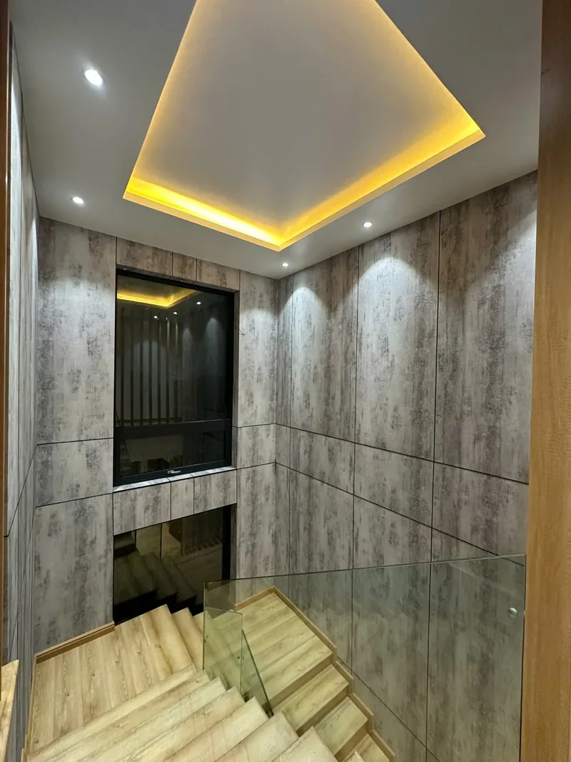 Sảnh thang — tường và trần cùng ốp một hệ vật liệu
