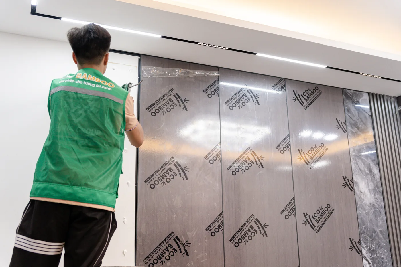 Bước 6 — áp tấm vào tường, màng bảo vệ vẫn còn nguyên